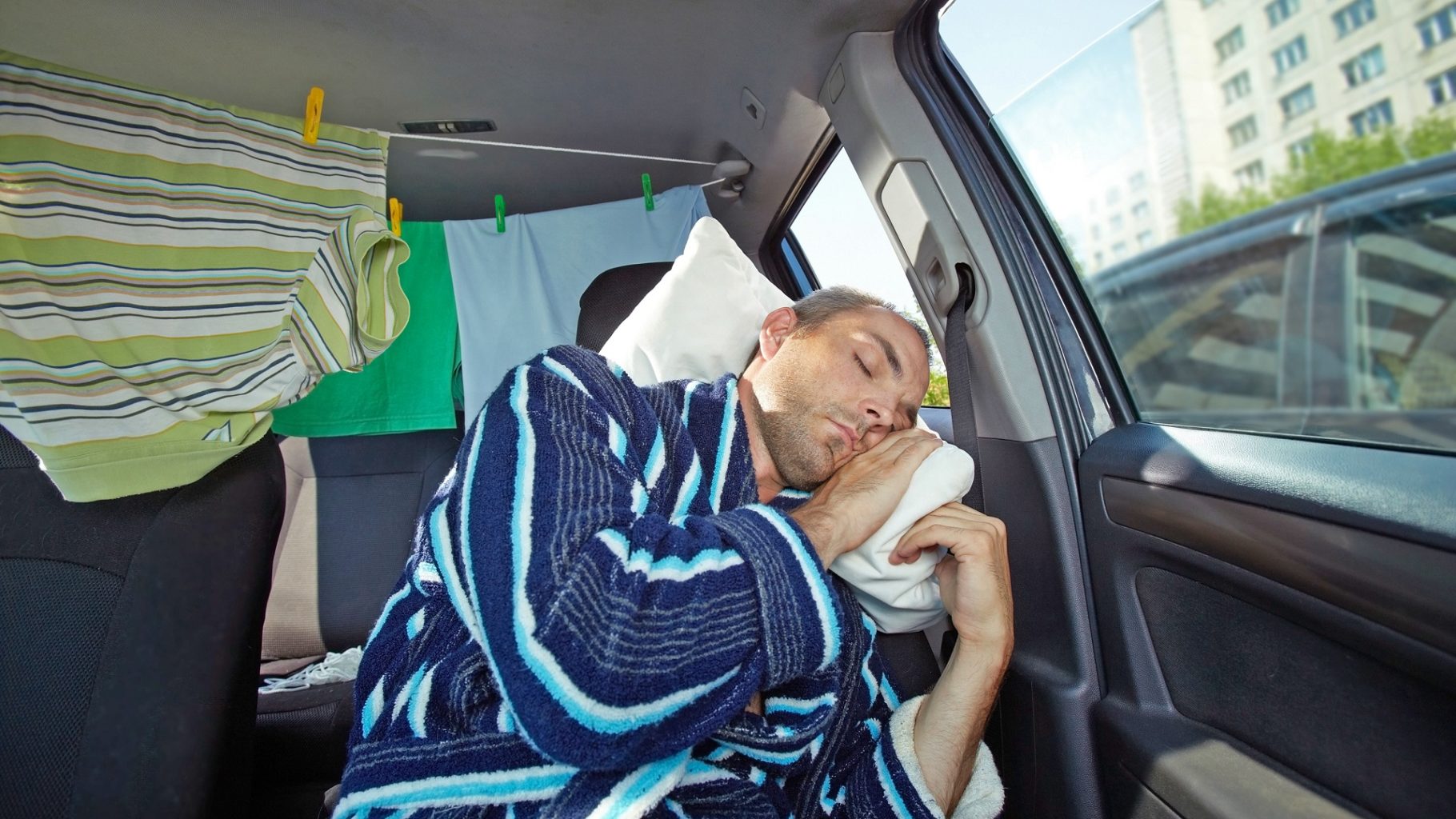 man sleeping inside his car